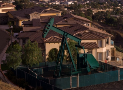 Fenced off green oil rig in suburbs