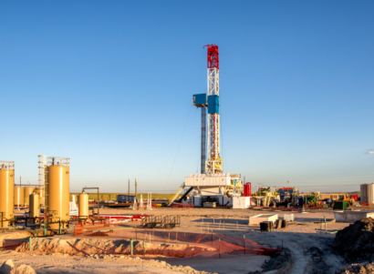 Fracking rig surrounded by dirt and oil fracking equipment