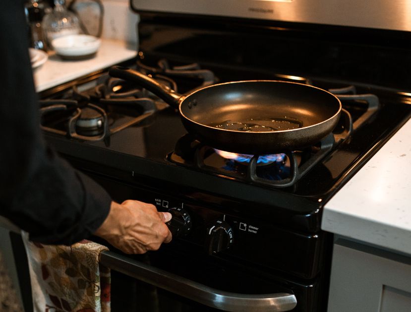 Image of a person lighting a gas stove.